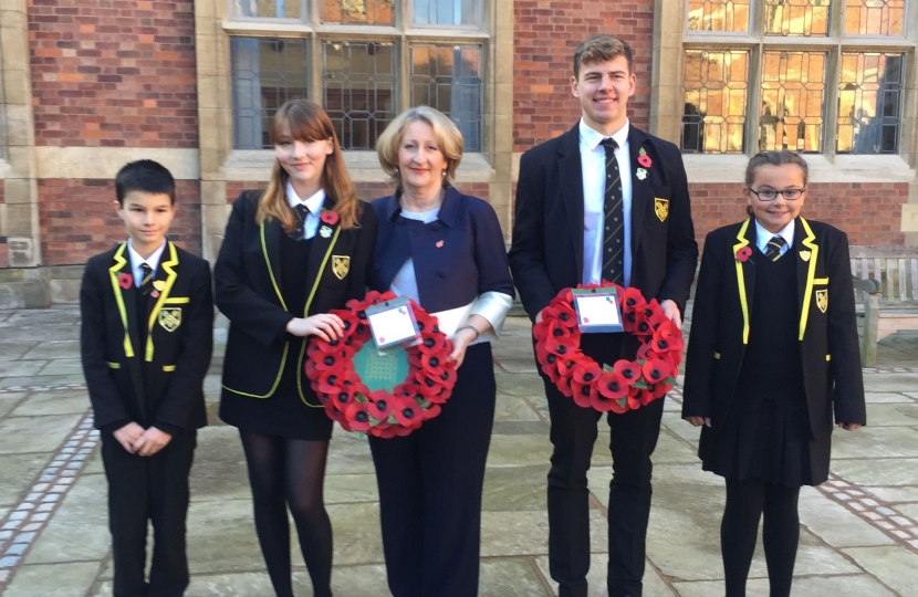 Mary Robinson pictured holding a wreath with pupils of Stockport Grammar